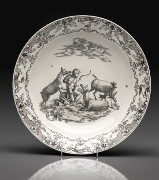 White porcelain plate decorated with a black and white scene of a seated nude boy with a bow su…
